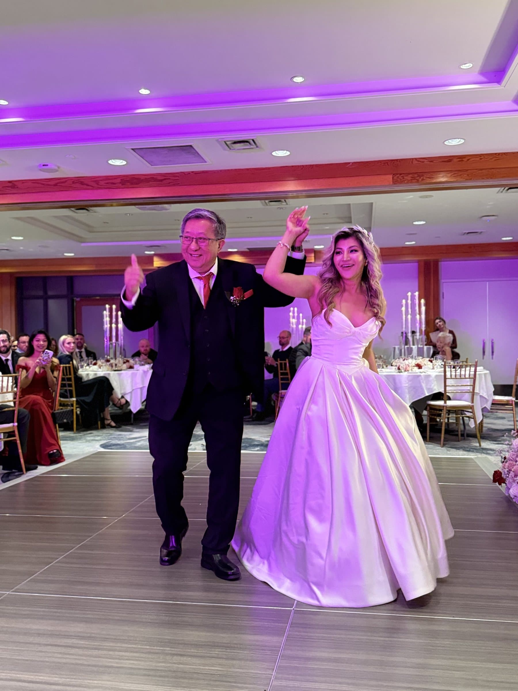 A grand entrance onto the dance floor under purple uplighting