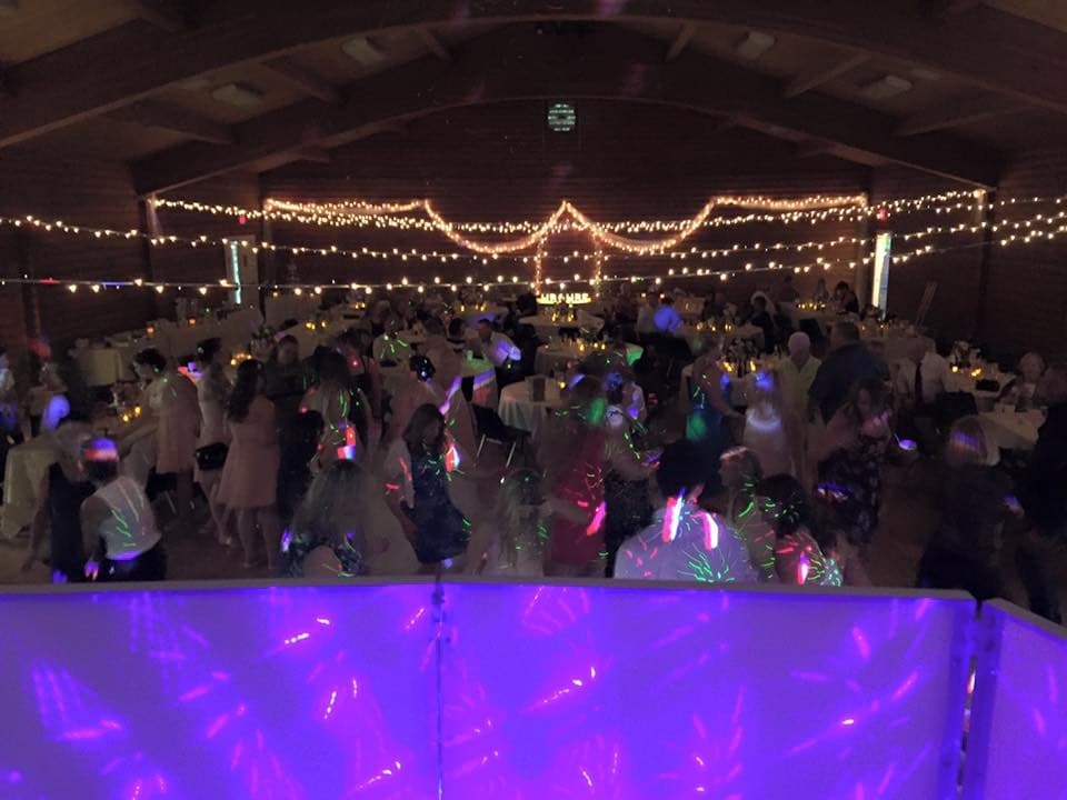 A packed Vancouver dance floor under string lights, guests dancing with glow sticks