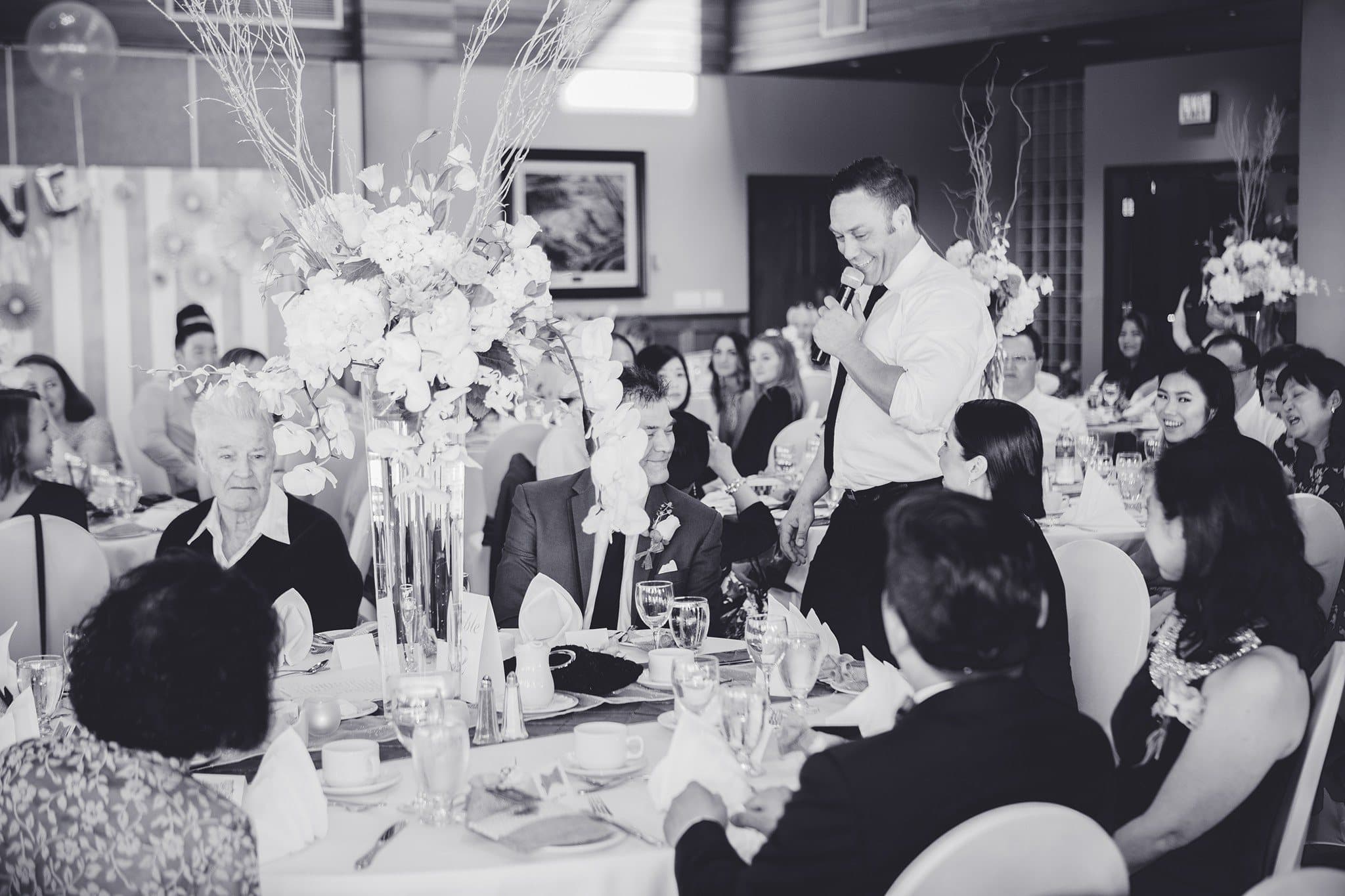 Vancouver MC on the microphone working a reception table by table