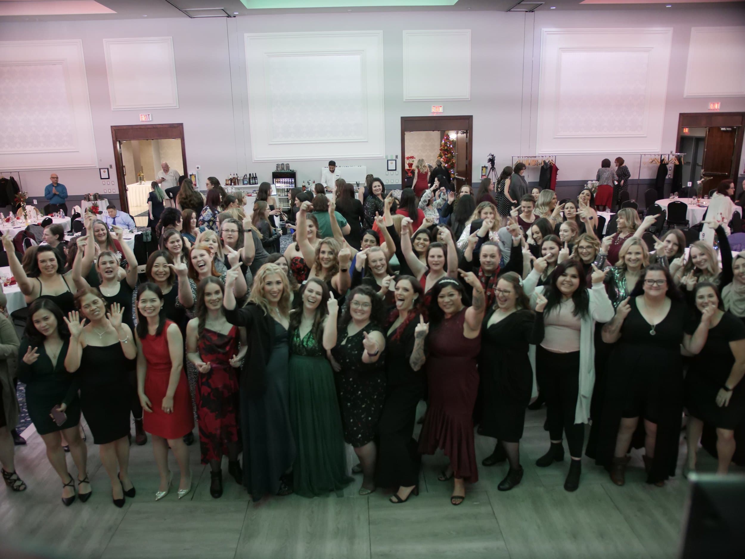 A full company group photo at a Vancouver holiday party, everyone with hands in the air