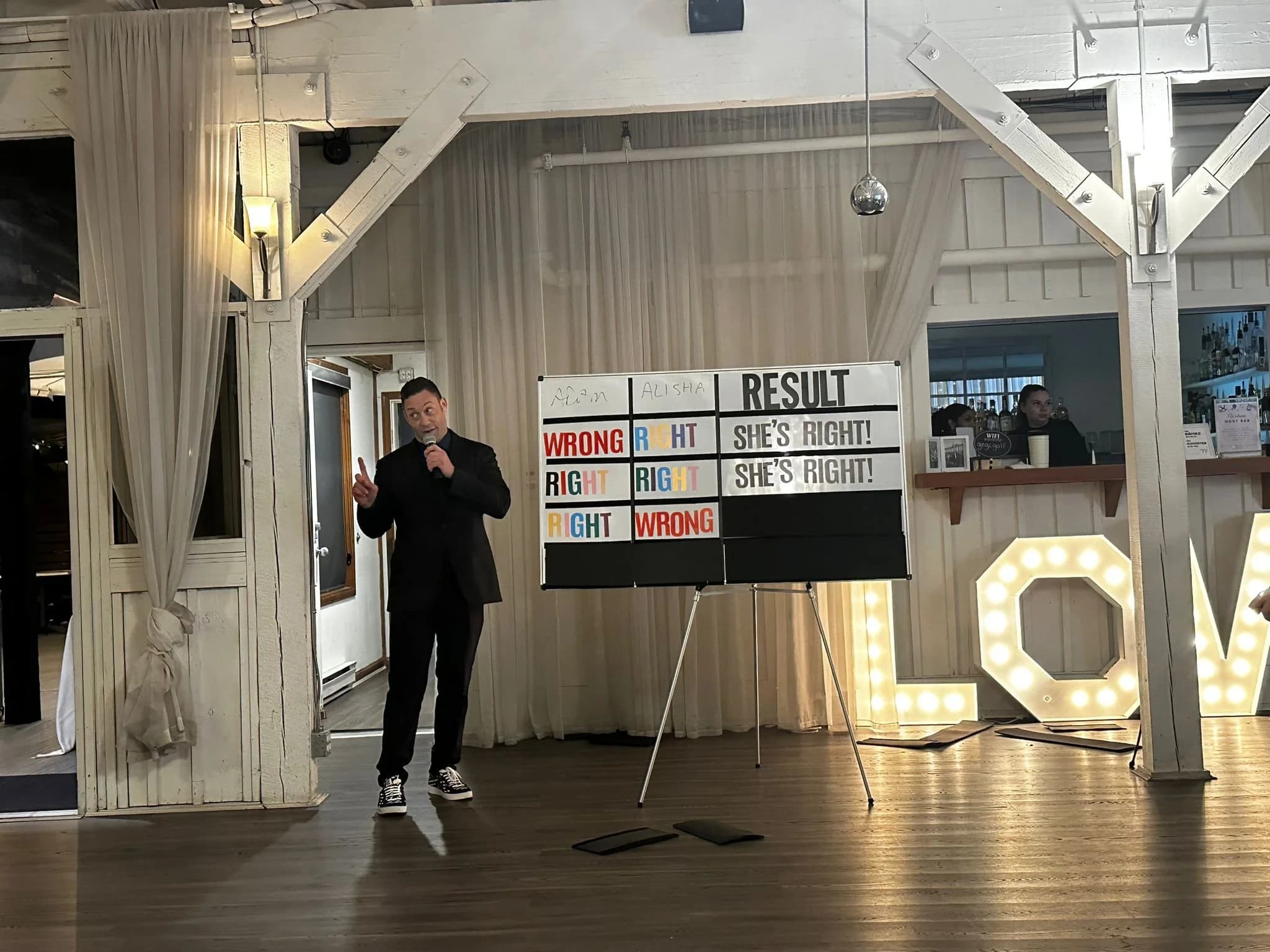 Mike Oulton running a newlywed game with a live scoreboard