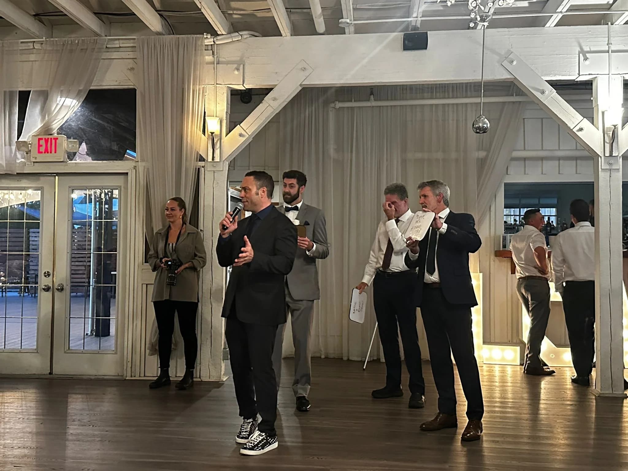 Guests playing a hosted wedding game with answer boards
