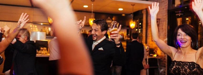 Guests celebrating at the bar with their hands up