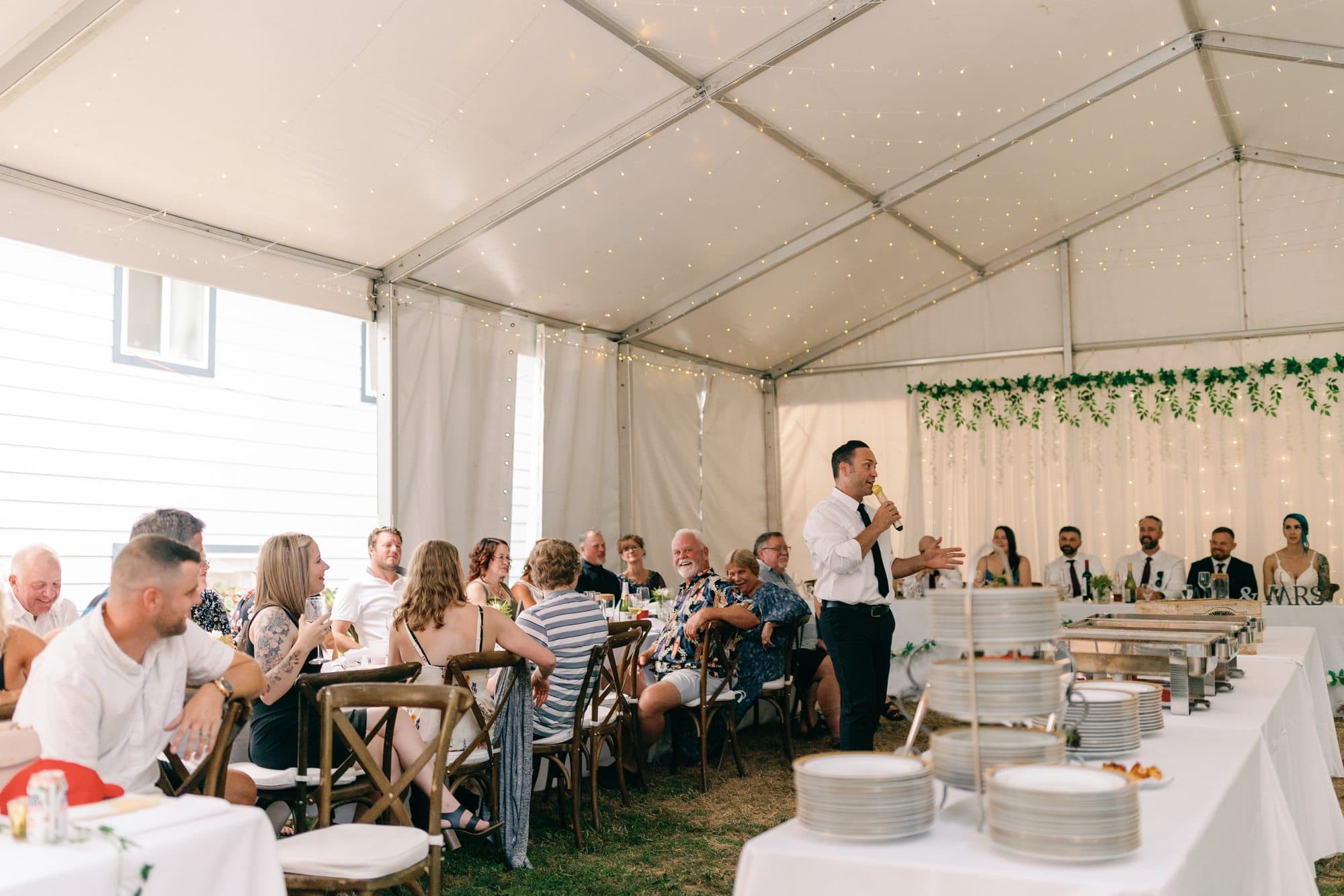 Wedding guests seated under a marquee during the reception